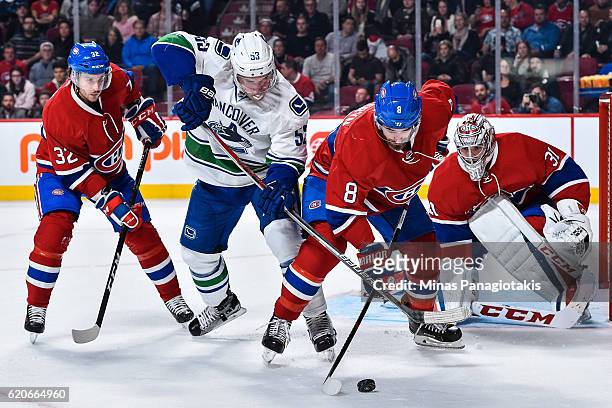 Goaltender Carey Price and teammate Brian Flynn watch as Bo Horvat of the Vancouver Canucks and Greg Pateryn of the Montreal Canadiens battle for the...