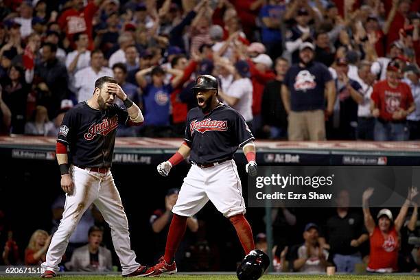 Jason Kipnis and Carlos Santana of the Cleveland Indians celebrate after scoring runs on a wild pitch thrown by Jon Lester of the Chicago Cubs during...
