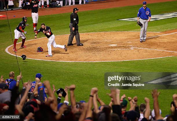 Jason Kipnis and Carlos Santana of the Cleveland Indians celebrate after scoring runs on a wild pitch thrown by Jon Lester of the Chicago Cubs during...