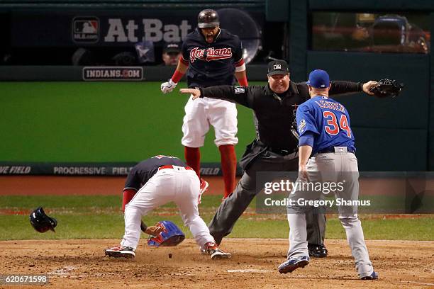 Jason Kipnis and Carlos Santana of the Cleveland Indians celebrate after scoring runs on a wild pitch thrown by Jon Lester of the Chicago Cubs during...