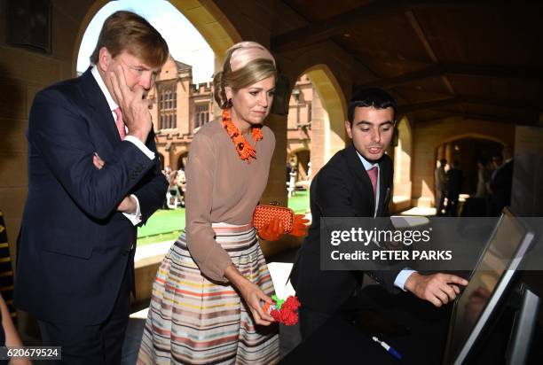 King Willem-Alexander of the Netherlands and Queen Maxima are shown work by a student on a visit to the University of Sydney in Sydney on November 3,...