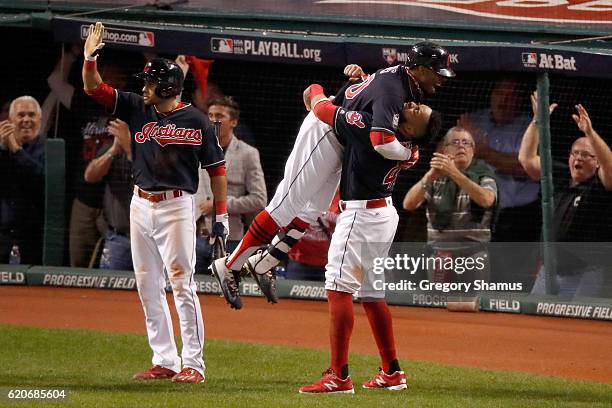 Rajai Davis of the Cleveland Indians celebrates with Carlos Santana after hitting a two-run home run during the eighth inning to tie the game 6-6...