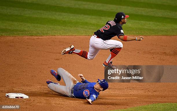 Francisco Lindor of the Cleveland Indians jumps over Chris Coghlan of the Chicago Cubs as Coghlan is out at second base in the ninth inning in Game...
