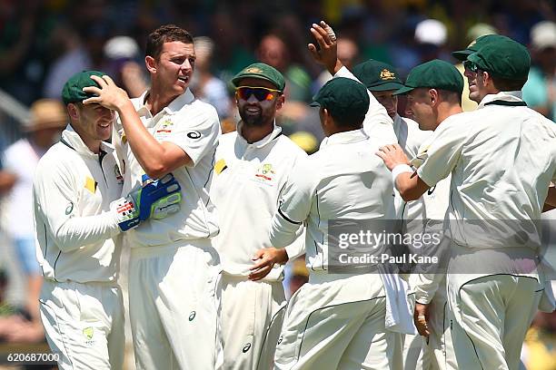 Josh Hazlewood of Australia celebrates with Peter Nevill after dismissing Dean Elgar of South Africa during day one of the First Test match between...