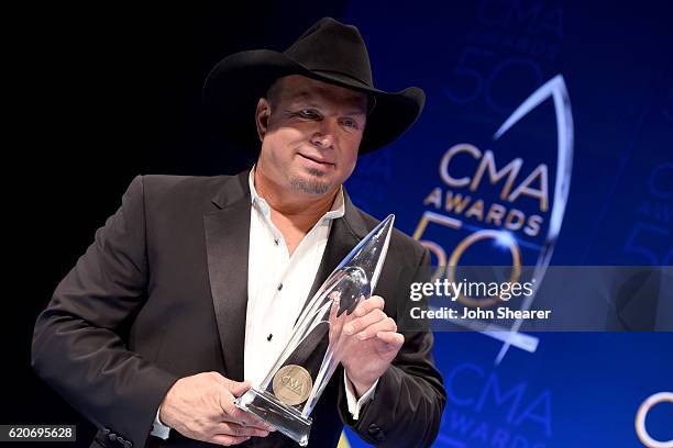 Garth Brooks poses with the award for Entertainer of the Year at the 50th annual CMA Awards at the Bridgestone Arena on November 2, 2016 in...