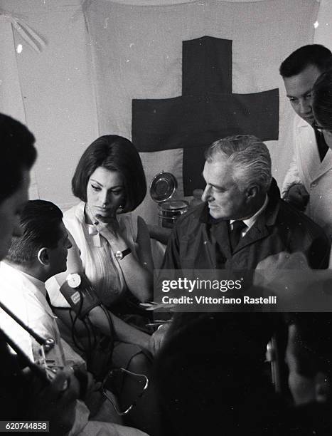 Rome, Italy. Italian actress Sophia Loren is seen with Italian movie director Vittorio de Sica, at right, who leads her in the crowd on her way to...