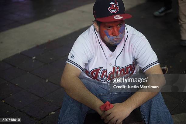 Cleveland Indians fan sits in the street after the Chicago Cubs defeated the Cleveland Indians in game 7 of the World Series in the early morning...