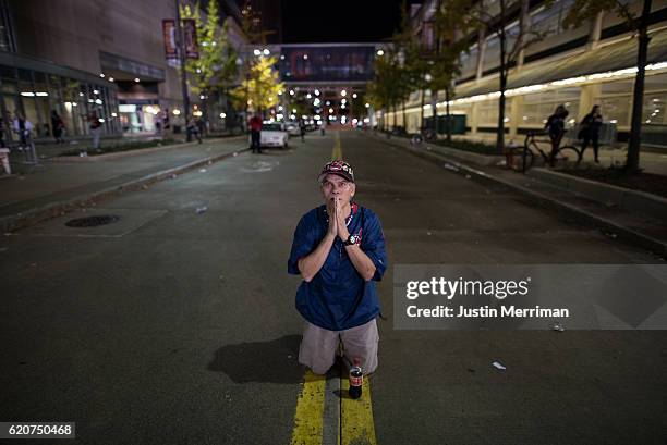 William Burgos of Cleveland prays in the street outside of Progressive Field during the 9th inning of game 7 of the World Series between the...