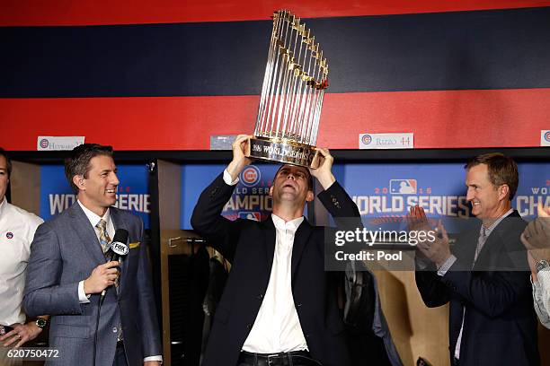 President of Baseball Operations for the Chicago Cubs Theo Epstein reacts with The Commissioner's Trophy after the Chicago Cubs defeated the...