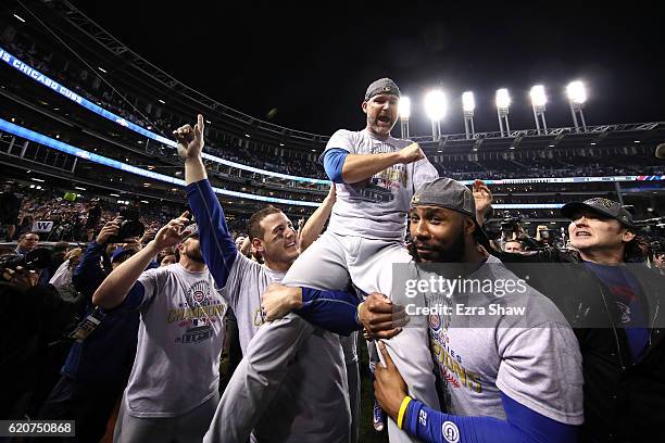 Anthony Rizzo, David Ross and Jason Heyward of the Chicago Cubs celebrate with actor John Cusack after defeating the Cleveland Indians 8-7 in Game...