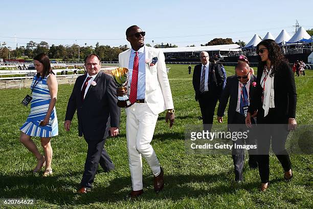 Usain Bolt carries the Crown Oaks Trophy before race 8, the Crown Oaks on Crown Oaks Day at Flemington Racecourse on November 3, 2016 in Melbourne,...