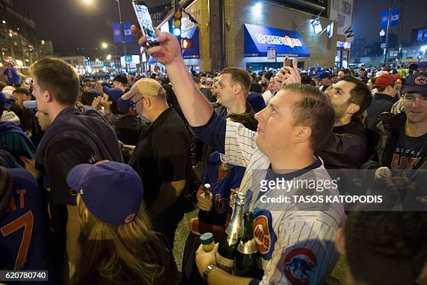 Chicago fans gather in the street to watch the Chicago Cubs take on the Cleveland Indians in Cleveland in game seven of the 2016 World Series, near...