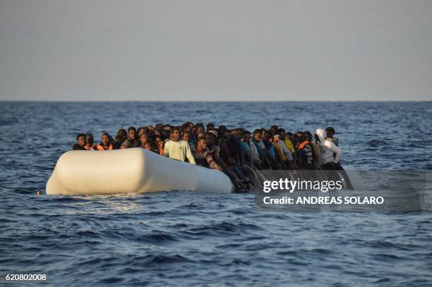 Migrants and refugees sit on a rubber boat before to be rescued by the ship Topaz Responder run by Maltese NGO Moas and Italian Red Cross off the...