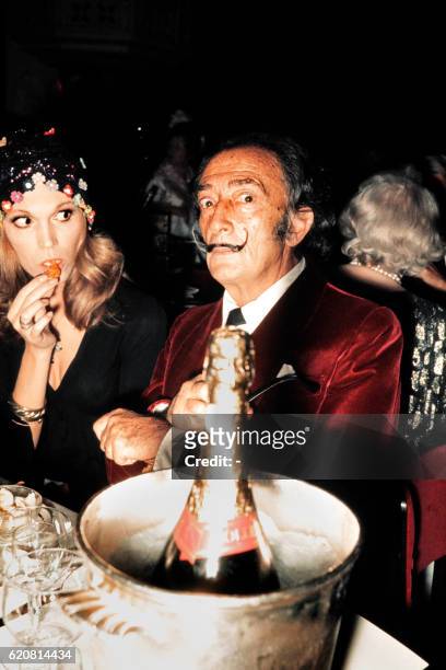Spanish painter Salvador Dali and French actress and singer Amanda Lear have dinner in a restaurant in Paris in December 1971.