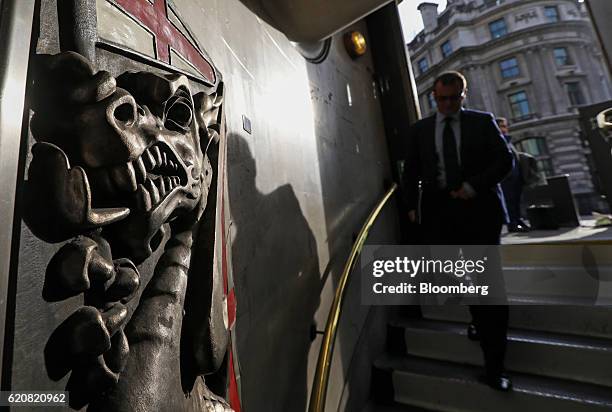 Pedestrian passes a relief of a City of London dragon on the walls of an exit to Bank underground station near the Bank of England , ahead of the...