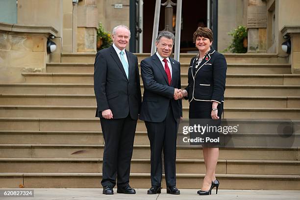 Colombian President Juan Manuel Santos shakes hands with First Minister Arlene Foster as Deputy First Minister Martin McGuinness looks on at Stormont...