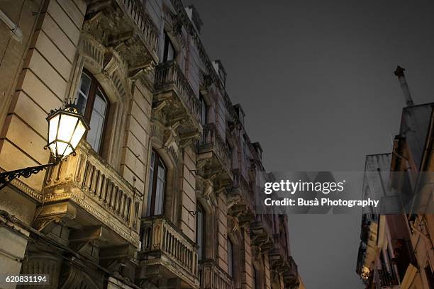 traditional cast-iron street lantern on facade of old building in taormina, sicily (italy), at twilight - ferro battuto foto e immagini stock