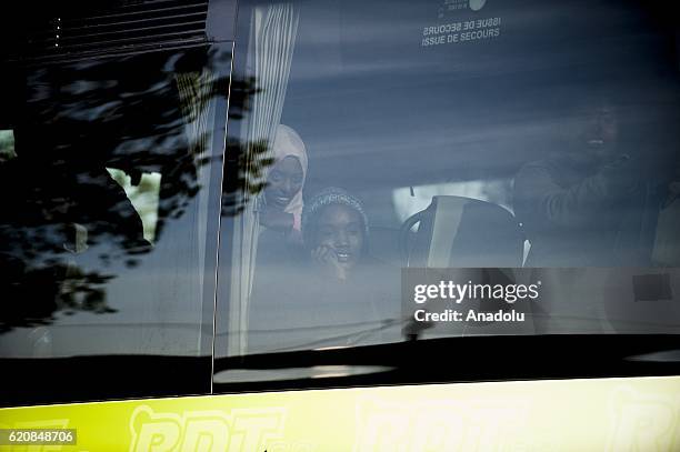 Two refugees look through the window of the bus leaving the center "Jules Ferry" in Calais, on November 3, 2016. Over 350 women and Their children,...