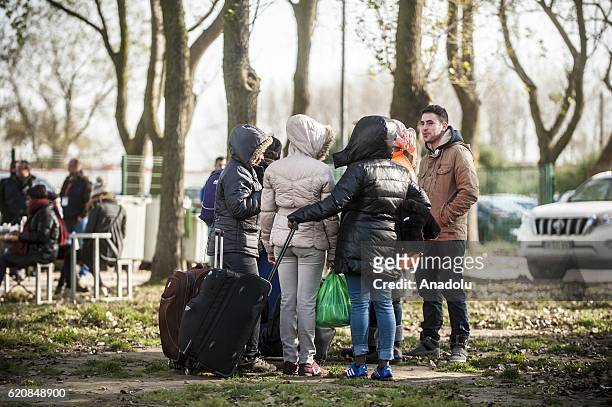 Women Refugees are waiting with their luggages to climb into a bus after leaving the "Jules Ferry" center reception, in Calais, on November 3, 2016....