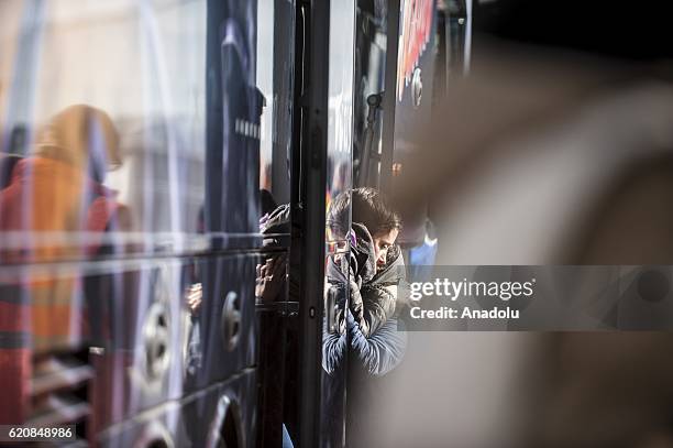 Two refugees get a hug before climbing into a bus after-leaving the "Jules Ferry" center reception, in Calais, on November 3, 2016. Over 350 women...