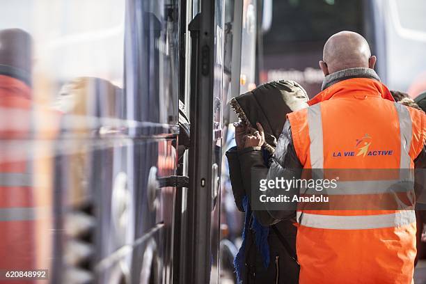 Refugee woman climb into a bus after-leaving the "Jules Ferry" center reception, in Calais, on November 3, 2016. Over 350 women and Their children,...