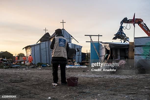 Volunteer from the "Catholic Relief" observes the destruction of the Eritrean church, last place of worship of the jungle in Calais, on November 3,...