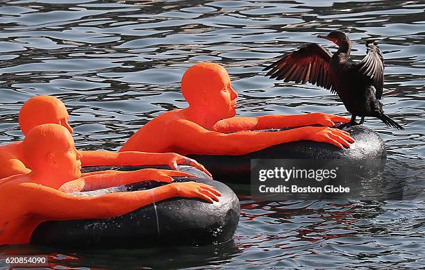 Bird lands on one of the foam figures that represents refugees in SOS , an art exhibition created by Ann Hirsh and Jeremy Angier, that floats in the...