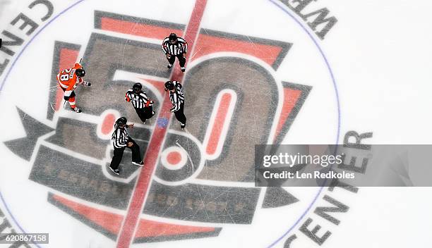 Officials Kyle Rehman, Francois St. Laurent, Steve Miller and Ryan Daisy prepare for the start of the second period with Claude Giroux of the...