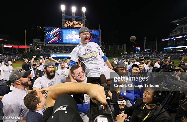 Chicago Cubs catcher David Ross is carried by Chicago Cubs first baseman Anthony Rizzo andChicago Cubs right fielder Jason Heyward after the Chicago...