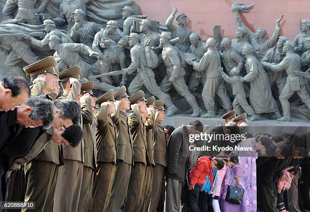 North Korea - Soldiers salute and citizens bow to bronze statues of former North Korean leaders Kim Il Sung and Kim Jong Il on Mansu Hill, Pyongyang,...