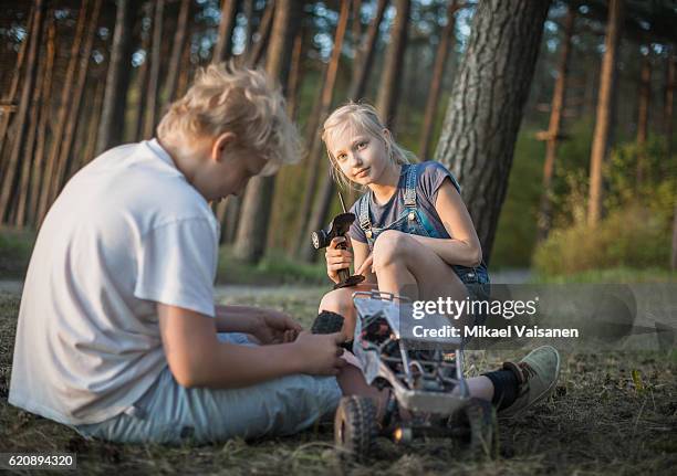 sister with her brother playing with remote controlled car - remote controlled car stockfoto's en -beelden