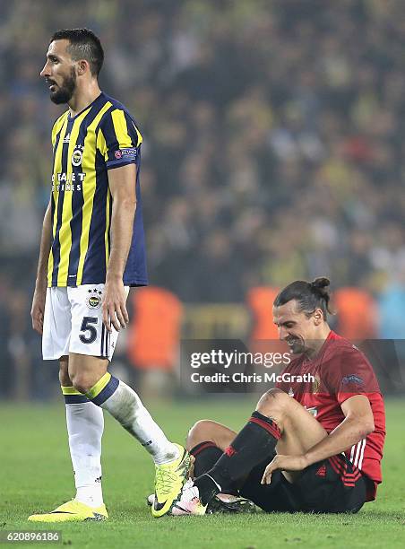 Zlatan Ibrahimovic of Manchester United holds his leg as Mehmet Topal of Fenerbahce looks on during the UEFA Europa League Group A match between...