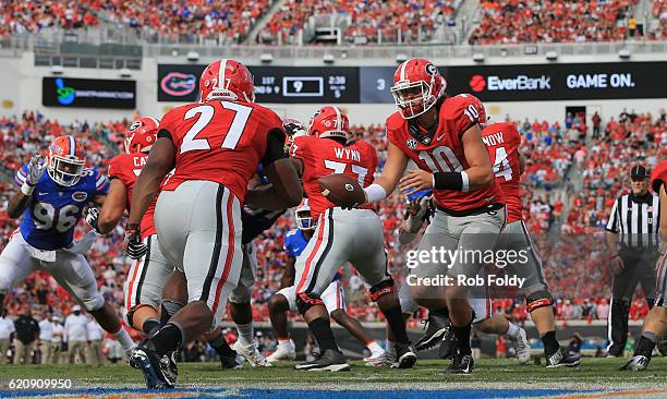Jacob Eason hands the ball off to Nick Chubb of the Georgia Bulldogs during the game against the Florida Gators at EverBank Field on October 29, 2016...