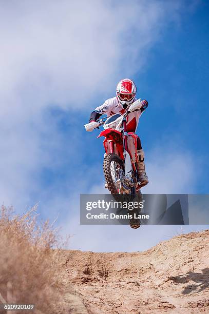 motorcyclist riding dirt bike on hillside - motocross photos et images de collection