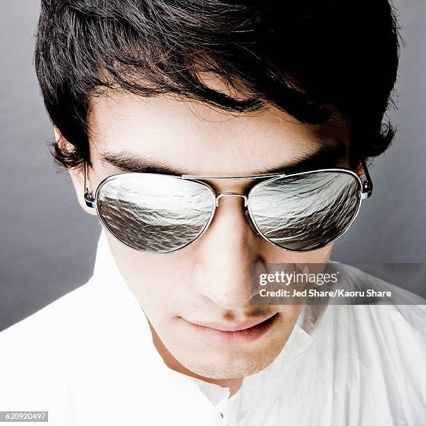 mixed race man in sunglasses reflecting water - man sunglasses face imagens e fotografias de stock