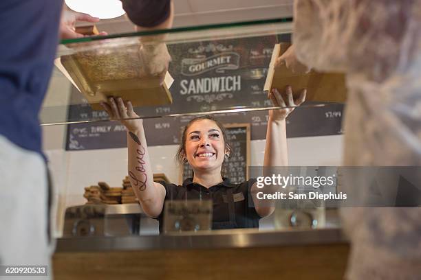 server handing pizza to customers in cafe - american pizza stock pictures, royalty-free photos & images