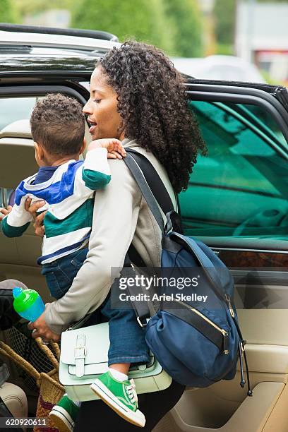 african american mother holding son near car - busy toddlers stock pictures, royalty-free photos & images