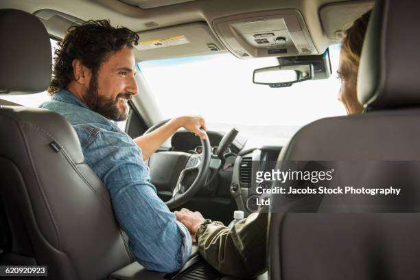 hispanic couple driving in car - man and woman holding hands profile stockfoto's en -beelden
