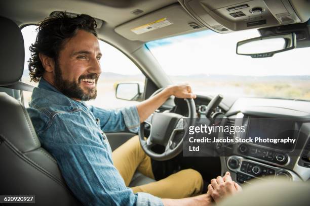 hispanic couple holding hands in car - guidare foto e immagini stock
