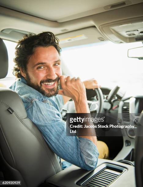 hispanic man driving car - driver portrait stock pictures, royalty-free photos & images