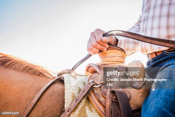 close up of hispanic man riding horse - rein stock pictures, royalty-free photos & images