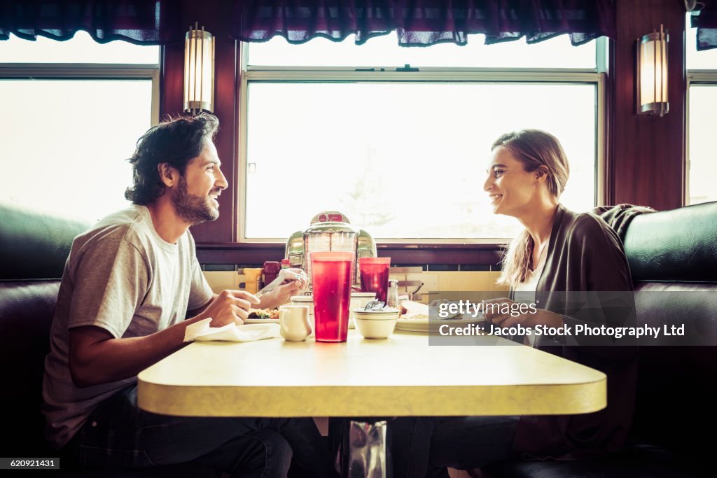 Hispanic couple eating breakfast in diner