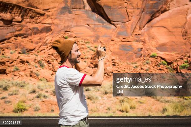 hispanic man photographing rock formation - profile shoot of founder of crossbow miles srishti bakshi stockfoto's en -beelden