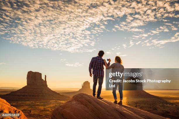 hispanic couple photographing remote desert - utah stock photos et images de collection