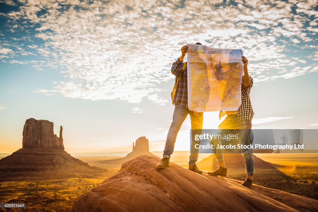 Hispanic couple reading map in remote desert