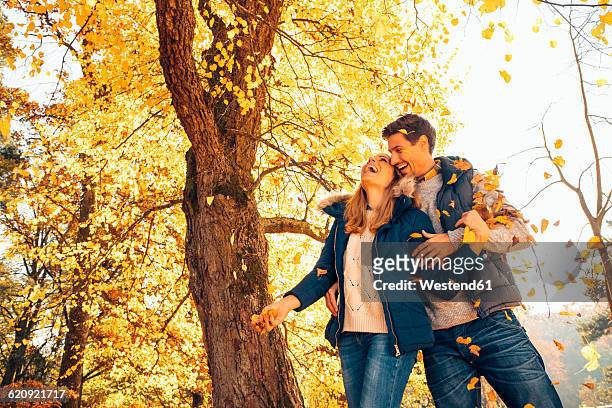 happy couple having fun in autumn in a forest - season 42 stock pictures, royalty-free photos & images
