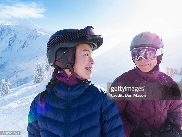 mother and daughter wearing ski gear on snowy mountain - family ice nature stock pictures, royalty-free photos & images