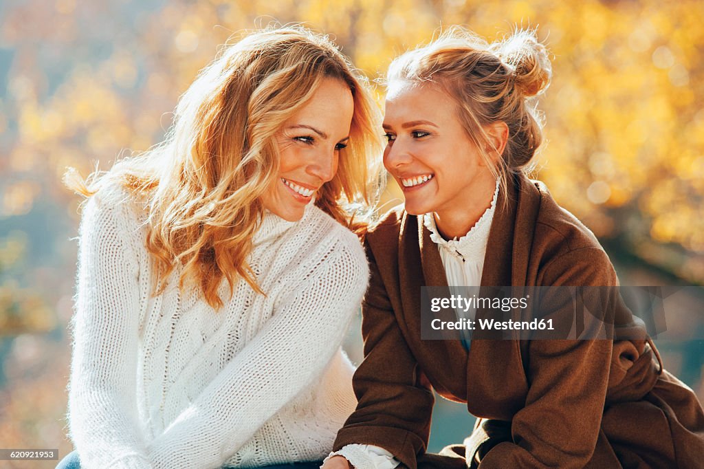 Happy mother and adult daughter in autumn
