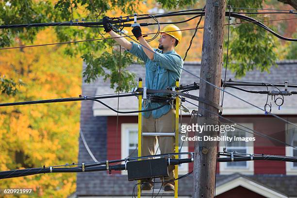 caucasian cable installer working on ladder - cable installer stock pictures, royalty-free photos & images