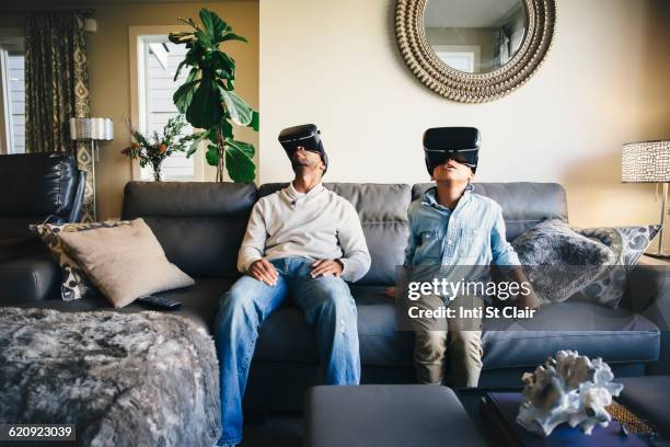 Mixed race father and daughter using virtual reality goggles